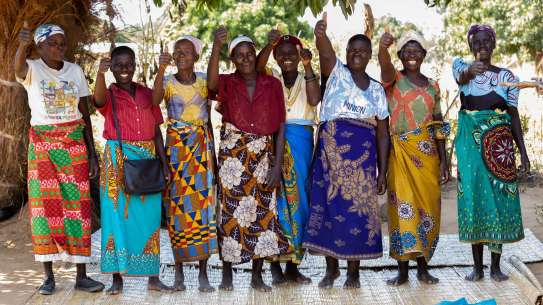 Women standing giving thumbs up