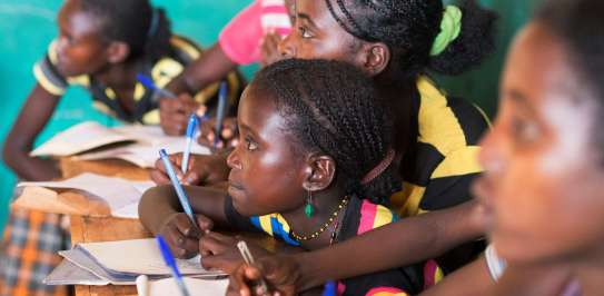 A group of children writing notes at school in Ethiopia