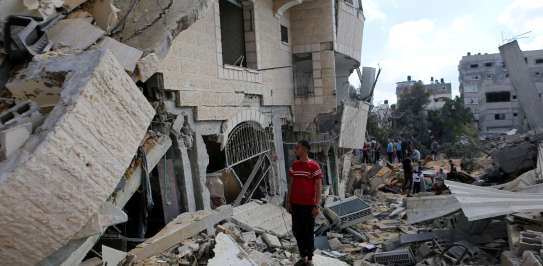 A man stands amongst the rubble of a destroyed building