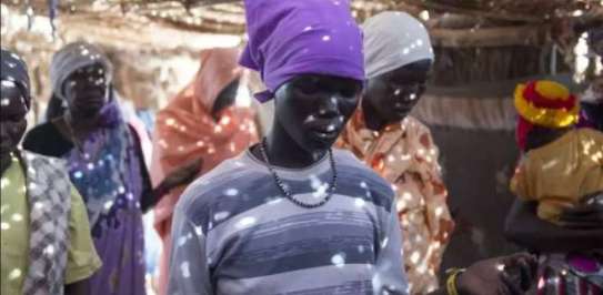 A woman prays with her community.