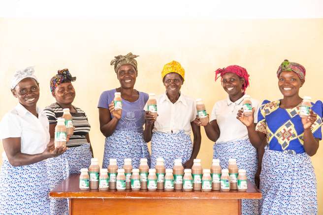 Eddina far left) and Janet (far right) with their Makande Womens Group and baobab juice