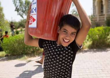 A boy carries a Christian Aid bucket in Iraq